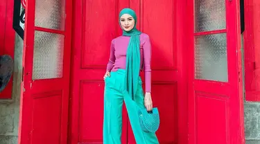 Tampil dengan busana berwarna serba tosca, Donita memilih untuk memadukannya dengan sebuah turtle neck berwarna ungu. Gaya hijab yang sederhana serta tas yang unik ini tak lepas dari perhatian netizen. (Liputan6.com/IG/@donitabhubiy)