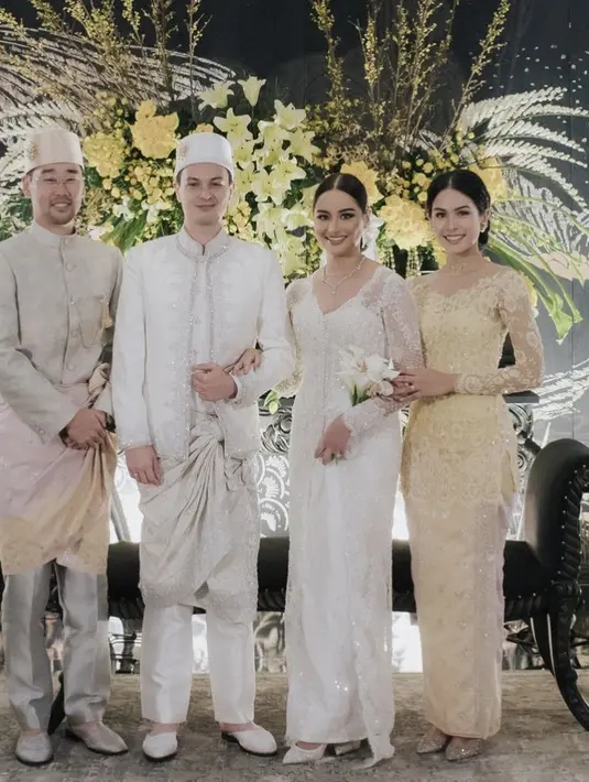 Jessy Choi mengenakan atasan warna serasi dengan peci dan bawahannya, ditambah songket.