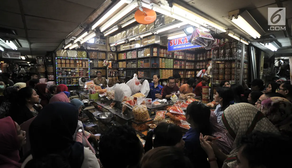Puluhan pembeli antre untuk mendapatkan kue kering untuk kebutuhan Lebaran di Pasar Jatinegara, Jakarta, Selasa (5/6). Kue panganan khas Idul Fitri tersebut dibanderol mulai dari Rp 40 ribu hingga Rp 200 ribu per kilogram. (Merdeka.com/ Iqbal S. Nugroho)