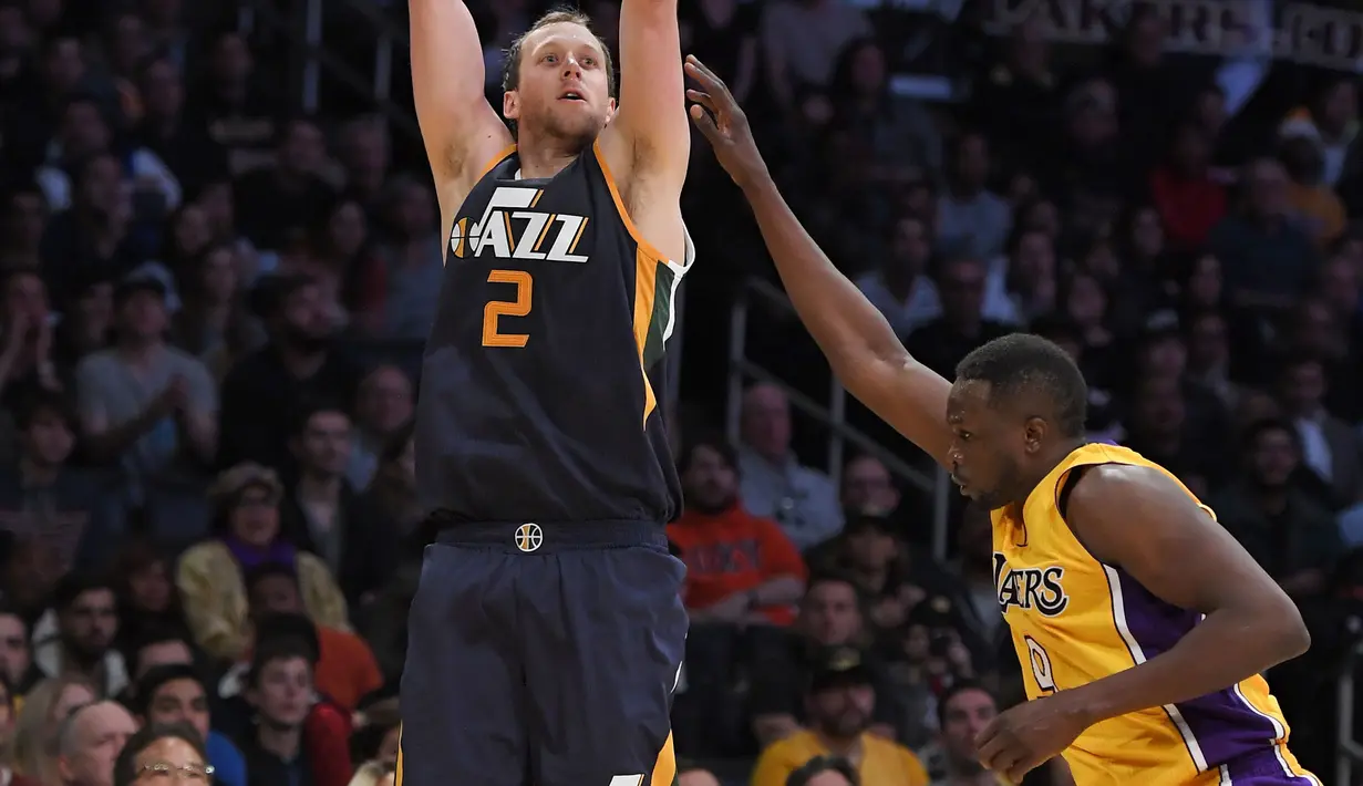 Pemain Utah Jazz,  Joe Ingles melakukan tembakan 3-poin saat dihadang pemain Los Angeles Lakers, Luol Deng pada laga NBA basketball game di Los Angeles, (27/12/2016).  (AP/Mark J. Terrill)