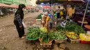 Seorang perempuan mengenakan masker saat membeli sayuran di pasar tradisional di tengah kabut asap tebal akibat kebakaran hutan dan lahan di Palangkaraya, Kalimantan Tengah, Senin (12/10/2026). Kabut asap menyelimuti sejumlah wilayah di Indonesia, Malaysia, dan Singapura selama beberapa pekan terakhir akibat kebakaran yang melanda kawasan hutan di Kalimantan dan Sumatra. Asap kebakaran terbawa angin hingga melintasi wilayah regional dan berdampak pada kualitas udara. (REINA/AFP)