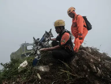 Personel tim pencarian dan penyelamatan melihat puing-puing pesawat turboprop Indonesia Air Transport berjenis ATR 42-500 di Gunung Bulusaraung, Sulawesi Selatan pada Minggu 18 Januari 2026. Tim gabungan terus mengoptimalkan operasi pencarian dan penyelamatan korban kecelakaan pesawat turboprop Indonesia Air Transport berjenis ATR 42-500 di Gunung Bulusaraung, Sulawesi Selatan. (Muchtamir Zaide/AFP)