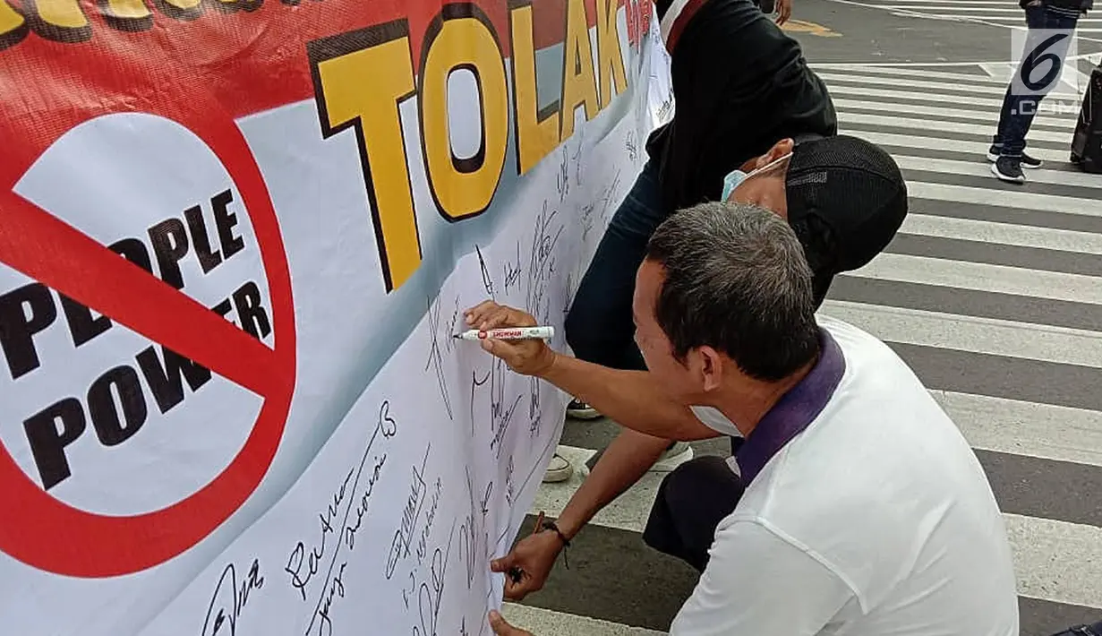 Masyarakat menandatangi spanduk petisi menolak gerakan people power saat car free day (CFD) di kawasan Thamrin, Jakarta, Minggu (19/5/2019). Aliansi Mahasiswa dan Pemuda Cinta NKRI mengajak masyarakat menandatangani petisi mendukung KPU dan Bawaslu pasca Pilpres 2019. (Liputan6.com/Faizal Fanani)
