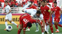Pemain Timnas Indonesia U-23, Muhammad Ferarri (kiri) dan pemain Uzbekistan U-23, Alibek Davronov terjatuh dalam perebutan bola pada laga semifinal Piala Asia U-23 2024 di Abdullah bin Khalifa Stadium, Doha, Qatar, Senin (29/4/2024). (AFP/Karim Jaafar)