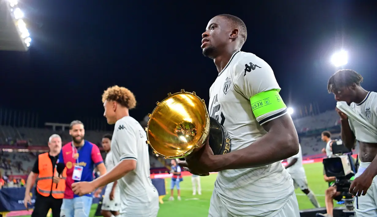Pemain AS Monaco, Denis Zakaria, membawa trofi setelah menjuarai Joan Gamper Trophy di Estadi Olimpic Lluis Companys, Selasa (13/8/2024) dini hari WIB. (AFP/Manaure Quintero)