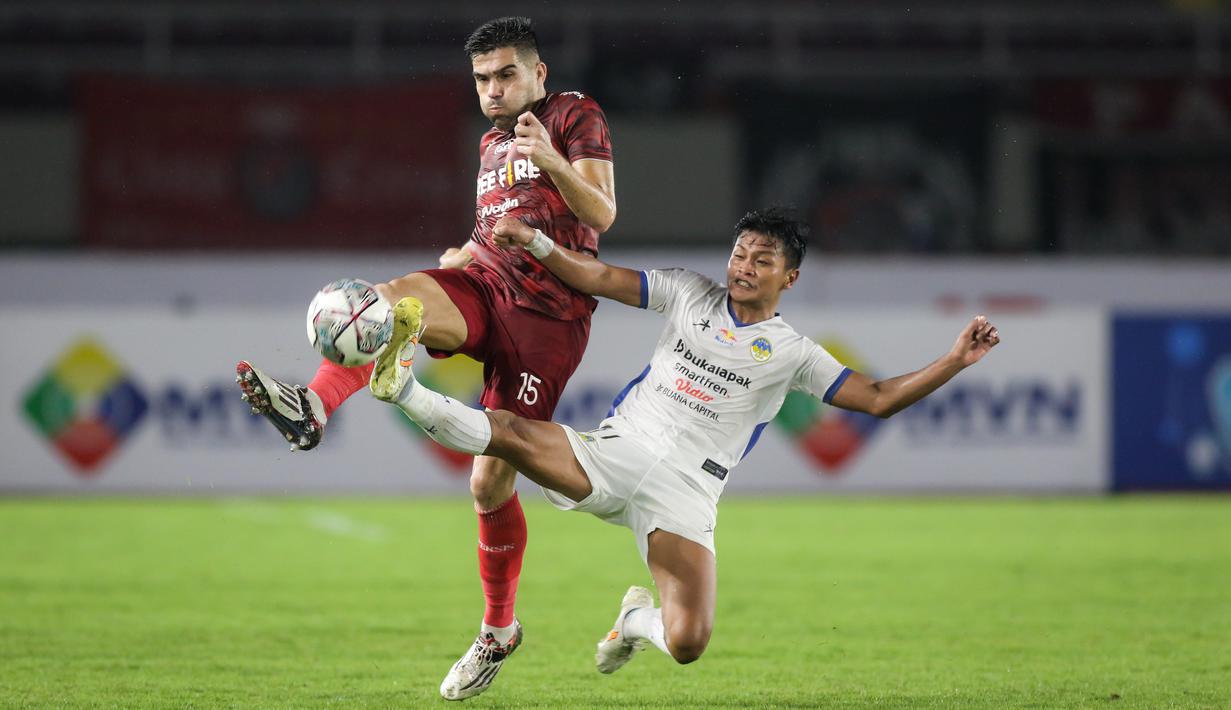 Pemain Persis Solo, Fabiano Da Rosa Beltrame (kiri) berebut bola dengan pemain PSIM Yogyakarta, Arbeta Rokyawan saat matchday ke-8 Grup C Liga 2 2021 antara Persis Solo melawan PSIM Yogyakarta di Stadion Manahan, Solo, Senin (15/11/2021). (Bola.com/Bagaskara Lazuardi)