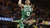 Aksi pemain Celtics, Jayson Tatum (0) melakukan tembakan saat diadang pemain Cavaliers, LeBron James (23) pada laga final Wilayah Timur NBA basketball di Quicken Loans Arena, Clevelan, (19/5/2018). Cavaliers menang 116-86. (AP/Tony Dejak)