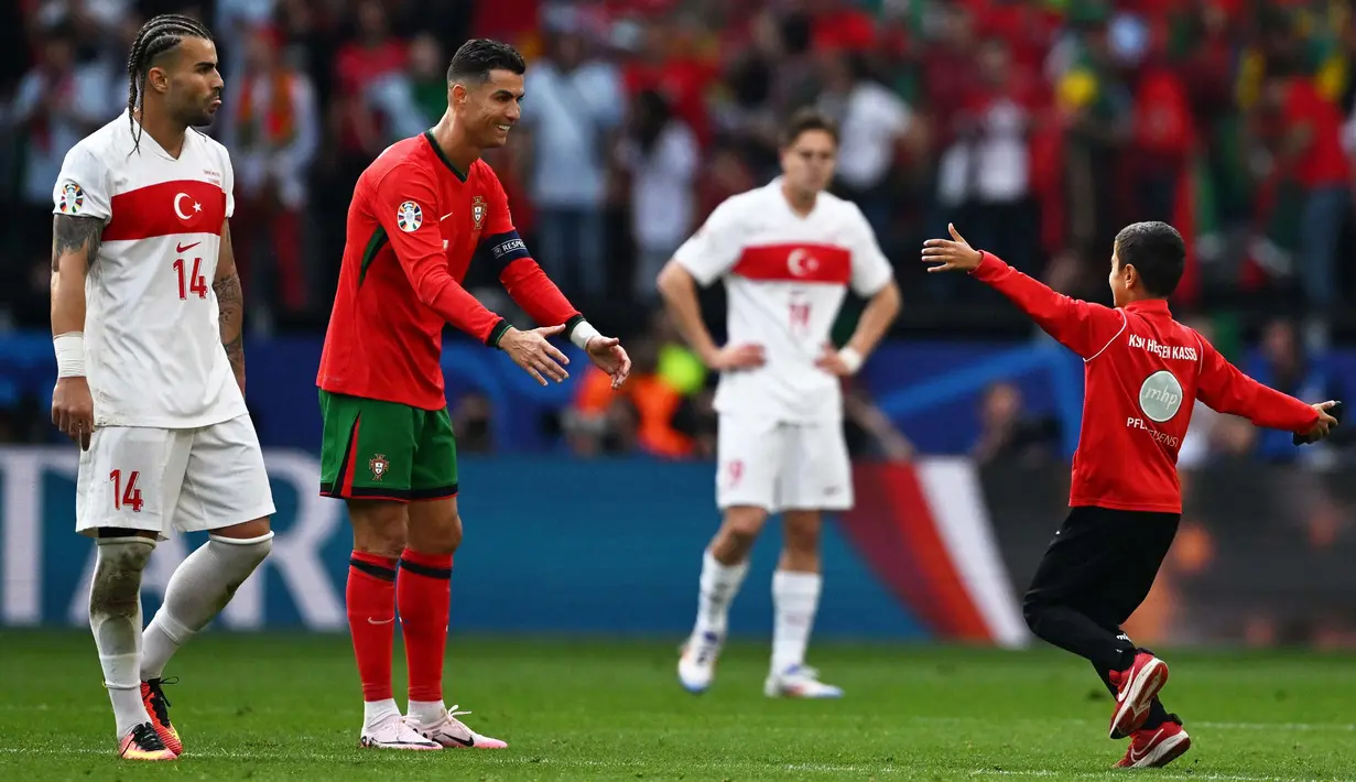 Laga Euro 2024 Grup F antara Turki dan Portugal terganggu oleh ulah sejumlah suporter yang masuk ke lapangan. (PATRICIA DE MELO MOREIRA/AFP)