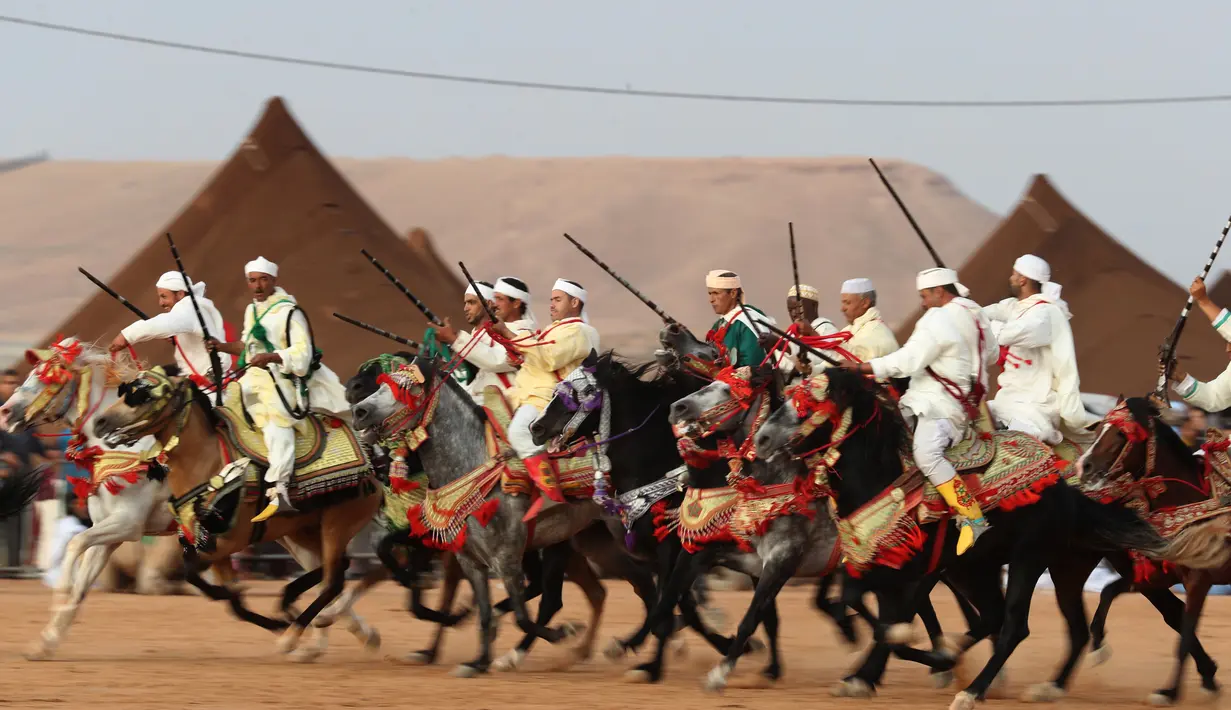 Aksi penunggang kuda saat upacara pembukaan Festival Tan-Tan Moussem Berber ke-14 di Kota Tan-Tan, Maroko, Jumat (6/7). Festival ini merupakan pertemuan terbesar suku nomaden di Afrika Utara. (KARIM SAHIB/AFP)