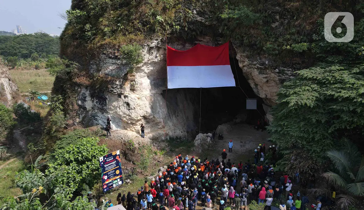 Suasana khidmat saat upacara pengibaran bendera Merah Putih pada HUT ke-78 RI di lokasi bekas tambang batu kapur Tebing Arpam, Gua Sigugula Karst Klapanunggal, Kabupaten Bogor, Jawa Barat, Kamis (17/8/2023). (merdeka.com/Imam Buhori)