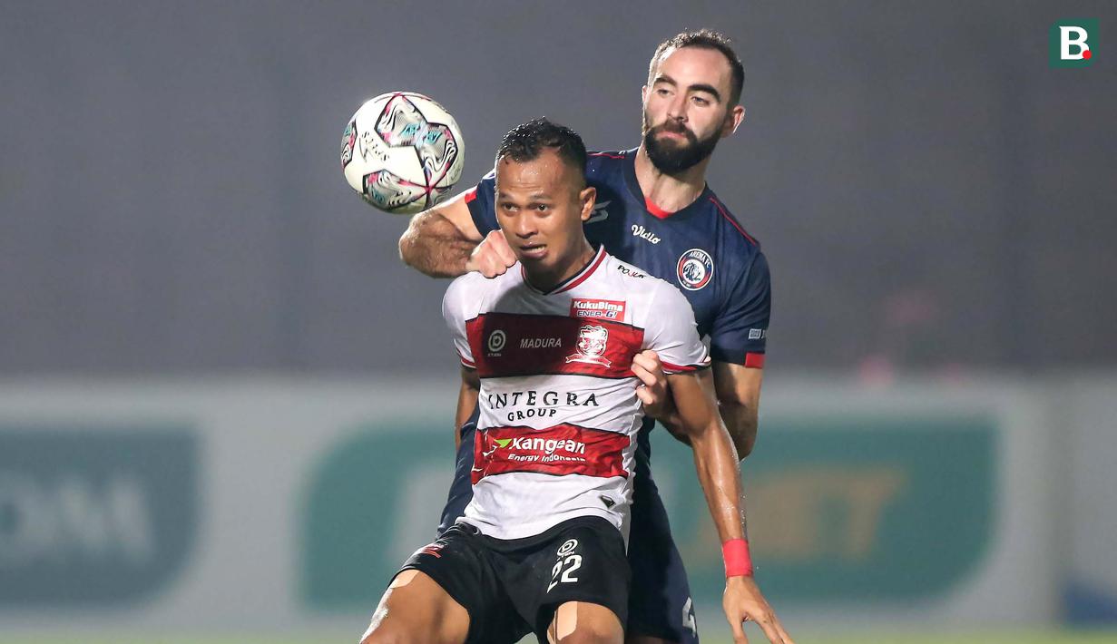 Madura United kembali dapat peluang lewat Sansan Fauzi (depan) di menit 23. Sansan yang mendapatkan kawalan ketat dari Sergio Domingos Reis Silva berhasil menendang bola ke gawang dan ditangkap kiper Arema FC. (Bola.com/Bagaskara Lazuardi)