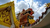 Kepala naga terlihat di atas kuil Buddha Wat Samphran (Kuil Naga) di Nakhon Pathom, sekitar 40 km sebelah barat Bangkok pada 11 September 2020. Kuil Buddha ini menjadi salah satu destinasi wisata di Thailand karena memiliki arsitektur menakjubkan. (Photo by Mladen ANTONOV / AFP)