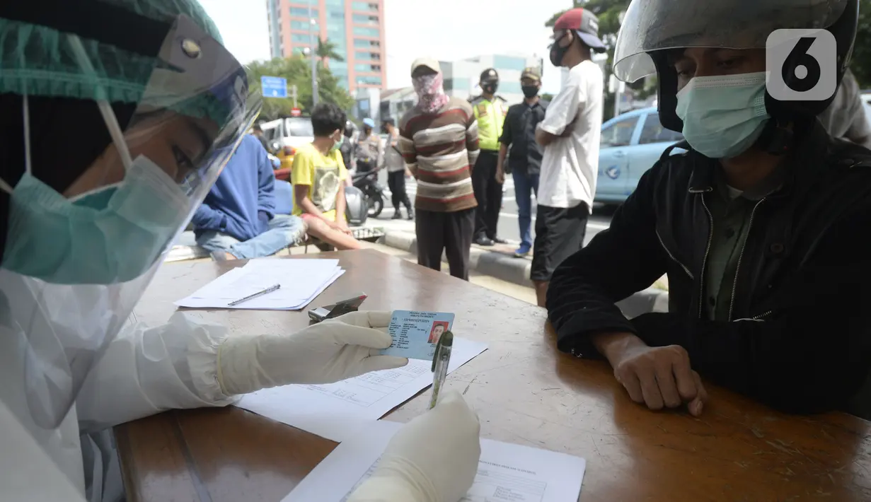 Petugas medis mendata pengendara yang terjaring razia masker di Jalan Panjang, Kedoya, Jakarta Barat, Senin (2812/2020). Pengendara yang tidak mengenakan masker langsung menjalani rapid test antigen gratis untuk mencegah penularan COVID-19. (merdeka.com/Dwi Narwoko)