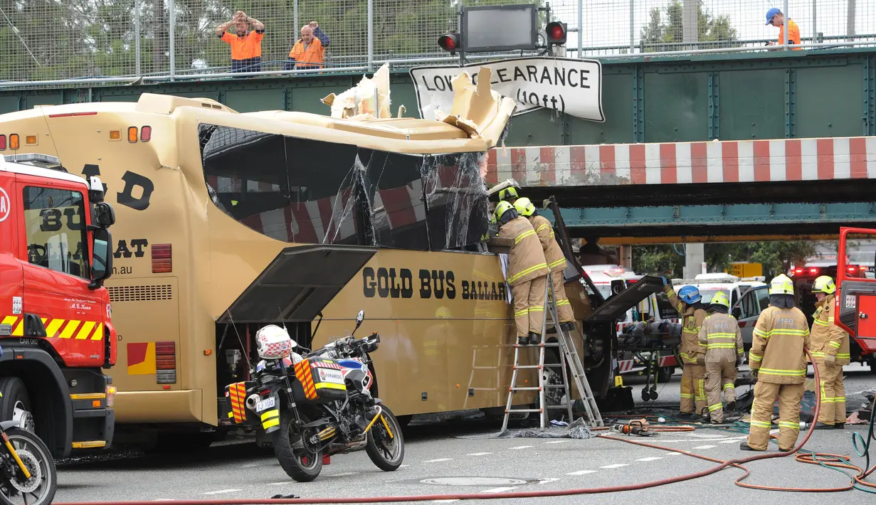 Petugas mengevakuasi penumpang dari dalam bus yang menabrak kolong jembatan kereta di Montague, South Melbourne, Australia (22/2). Belum diketahui penyebab tertabraknya bus yang mengangkut 19 orang ini. (REUTERS/Mal Fairclough)
