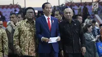 Presiden Joko Widodo (tengah) didampingi oleh Ketua DPD Oesman Sapta Odang (kiri) dan Kepala Staf Presiden Teten Masduki saat menghadiri acara Sarasehan Nasional DPD RI di Senayan, Jakarta, Jumat (17/11). (Liputan6.com/Angga Yuniar)