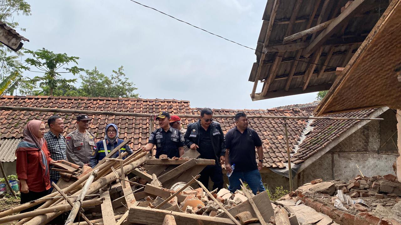 Pj. Bupati Garut Barnas Adjidin bersama petugas BPBD dan petugas gabungan lainnya saat meninjau salah satu rumah warga yang terdampak gempa magnitudo 4,2 kemarin. (Liputan6.com/Jayadi Supriadin)