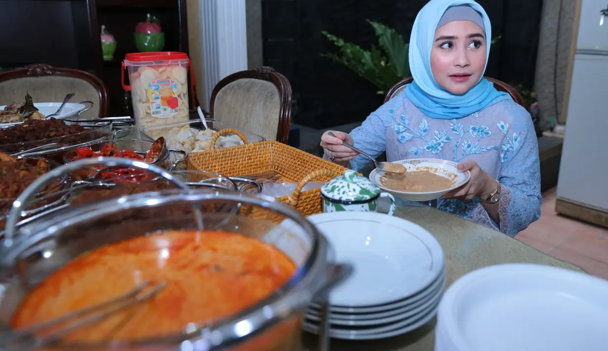 Meski perut terasa lapar, namun Prilly tidak bisa makan sembarangan. Makanan bayi menjadi santapan Prilly saat keluarga dan teman-temannya menikmati masakan khas lebaran. (Adrian Putra/Bintang.com)