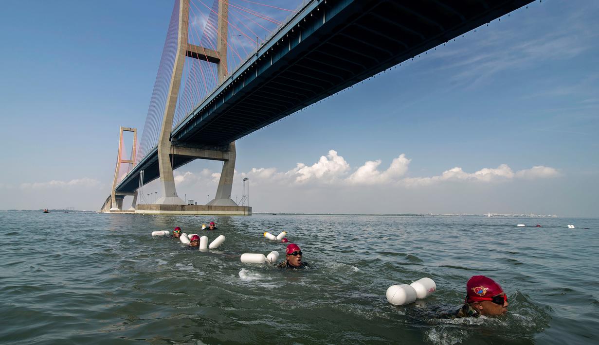 Prajurit Korps Marinir TNI AL berenang melintas selat Madura dari Surabaya sepanjang 5,4 km, Kamis (28/4). Renang yang mengambil start di Jembatan Suramadu dan finish di Bangkalan Madura ini untuk memperingati HUT Pasmar 1 ke-15. (Juni KRISWANTO/AFP)
