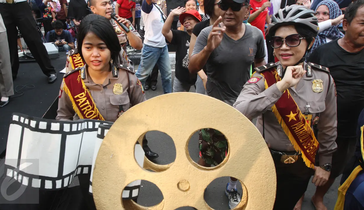 Sejumlah Polisi membawa replika rol film di Bundara HI, Jakarta, Minggu (16/4). Festival digelar agar masyarakat memahami tugas Kepolisian. (Liputan6.com/Angga Yuniar)