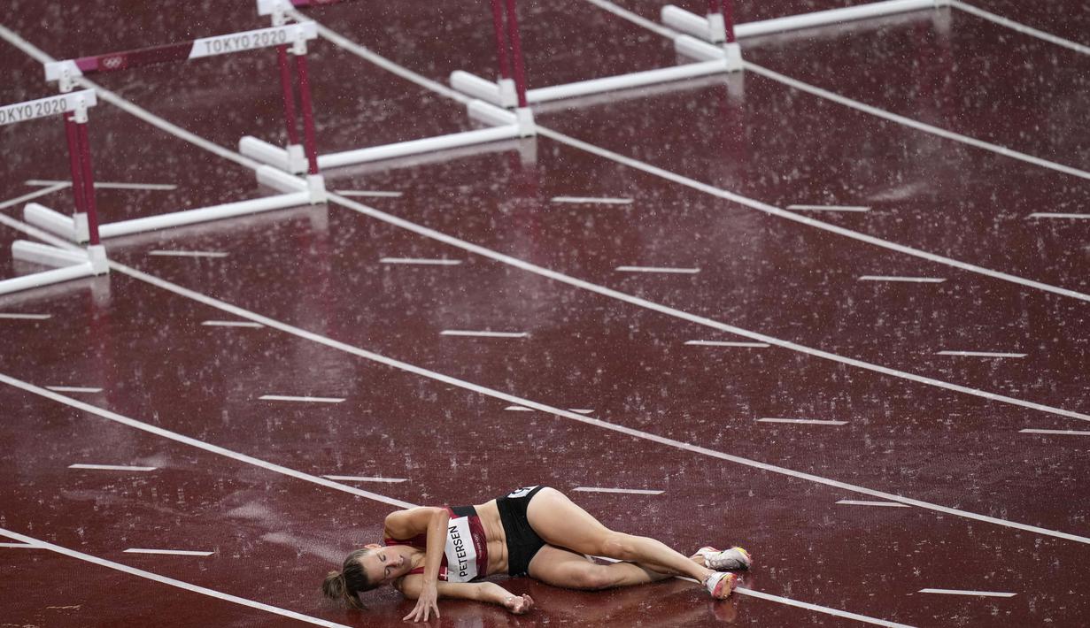 Sara Petersen, dari Denmark, terbaring di lintasan setelah terjatuh saat pertandingan semifinal lari gawang 400 meter putri pada Olimpiade Tokyo 2020,  Senin (2/8/2021). (Foto: AP/Francisco Seco)