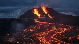 Pemandangan aliran lahar dari letusan gunung berapi di Semenanjung Reykjanes, barat daya Islandia, Senin (29/3/2021). Letusan gunung berapi tersebut masih menarik ribuan orang yang berharap untuk mendekati aliran lahar. (AP Photo/Marco Di Marco)