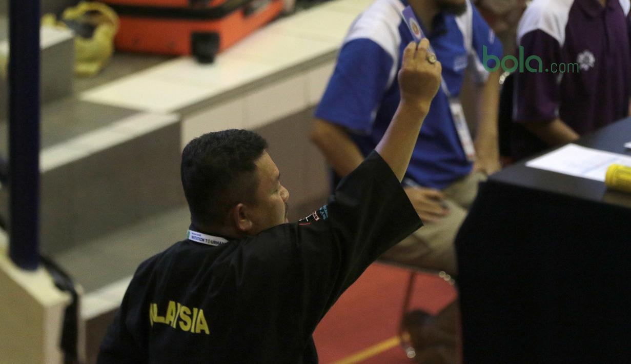 Pelatih Malaysia melakukan protes saat anak asuhnya Shukor M. Z. Hakim melawan Arafa M. Yachser pada semifinal putra kelas 55 kg - 60 kg Test Event Pencak Silat di Padepokan Silat TMII, Jakarta, (12/2/2018). Arafa menang 5-0. (Bola.com/Nick Hanoatubun)