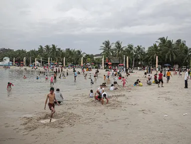 Pengujung berwisata di Pantai Ancol, Jakarta, Rabu (28/12/2022). Isu cuaca yang kurang bersahabat pada hari ini, tidak menyurutkan keinginan warga menghabiskan libur untuk berwisata di kawasan wisata Ancol. (Liputan6.com/Faizal Fanani)