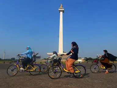 Pengunjung menggunakan sepeda dari layanan bike sharing di Monas, Jakarta, Jumat (27/7). Layanan ini merupakan kerja sama antara Smart City dan GOWES selaku operator bike sharing. (Merdeka.com/Imam Buhori)
