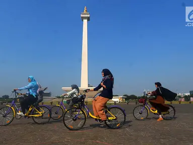 Pengunjung menggunakan sepeda dari layanan bike sharing di Monas, Jakarta, Jumat (27/7). Layanan ini merupakan kerja sama antara Smart City dan GOWES selaku operator bike sharing. (Merdeka.com/Imam Buhori)
