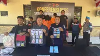 Kasat Reskrim Polresta Balikpapan Komisaris Polisi Ricky Sibarani (tengah) saat menunjukan barang bukti hasil kejahatan penipuan jual beli emas yang dilakukan pasangan suami istri. (Apriyanto/Liputan6.com)