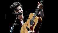 Shawn Mendes memang selalu identik dengan gitar akustik miliknya. (Liputan6.com/AFP)