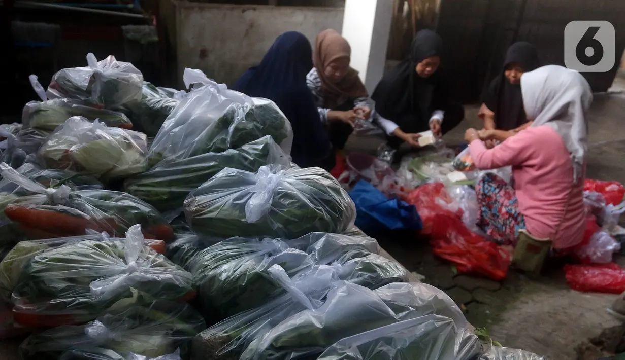 Sejumlah wanita mengemas sayuran ke dalam plastik untuk dibagikan kepada warga. (merdeka.com/Arie Basuki)