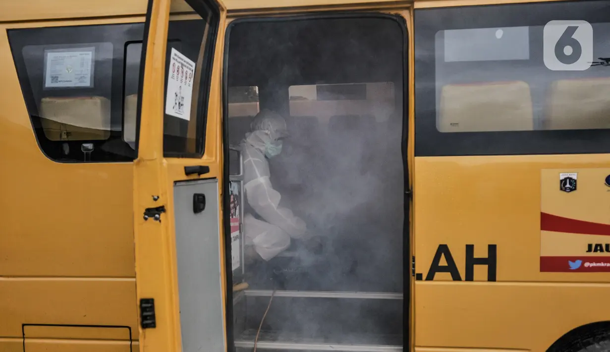 Pengasapan antibakteri pada bus sekolah di Pool Unit Pelayanan Angkutan Sekolah (UPAS) DKI Jakarta, Kramat Jati, Selasa (5/1/2021). Sterilisasi dan pengasapan antibakteri bus sekolah dilakukan usai digunakan mengangkut pasien terpapar Covid-19 menuju rumah sakit rujukan. (merdeka.com/Iqbal Nugroho)
