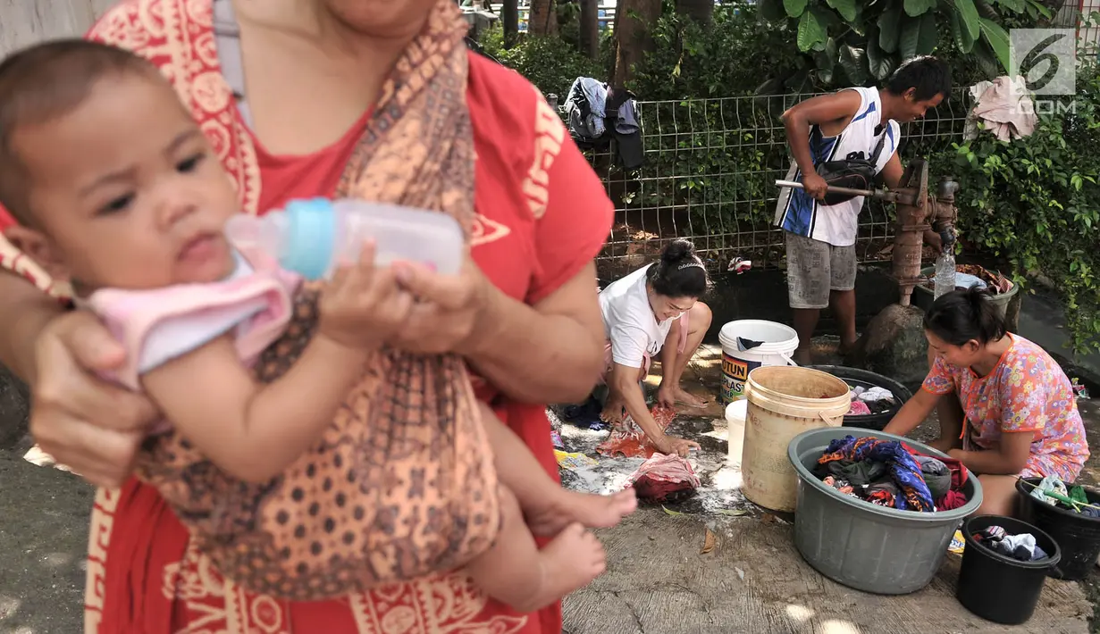 Warga mencuci pakaian di pinggir jalan kawasan Kramat Pulo, Senen, Jakarta, Kamis (27/12). Minimnya tempat MCK pribadi memaksa warga di Kramat Pulo menggunakan lahan di pinggir jalan untuk mencuci pakaian dan piring mereka. (Merdeka.com/Iqbal S. Nugroho)