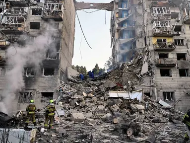 Tim penyelamat Ukraina melakukan pencarian dan penyelamatan di sebuah bangunan tempat tinggal yang rusak parah setelah serangan rudal Rusia di Kyiv pada tanggal 17 Juni 2025, di tengah invasi Rusia ke Ukraina. (Genya SAVILOV/AFP)