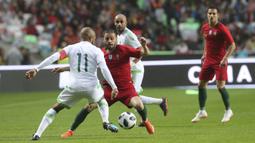 Striker Portugal, Bernardo Silva, berusaha melewati pemain Aljazair, Yacine Brahimi, pada laga uji coba di Estadio da Luz, Jumat (8/6/2018). Portugal menang 3-0 atas Aljazair. (AP/Armando Franca)