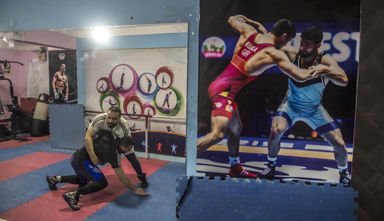 Pengungsi Suriah Amir al-Awad (kaos putih) mencohtohkan gerakan kepada siswanya di Akademi Olahraga Suriah di Alexandria, Mesir (4/1). (AFP/Khaled Desouki)