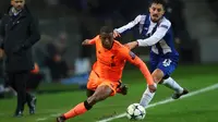Pemain Liverpool, Georginio Wijnaldum berebut bola dengan pemain FC Porto, Alex Telles dalam leg pertama babak 16 besar Liga Champions di Stadion Do Dragao, Kamis (15/2). Liverpool sukses menundukkan Porto dengan skor 5-0. (AP/Luis Vieira)
