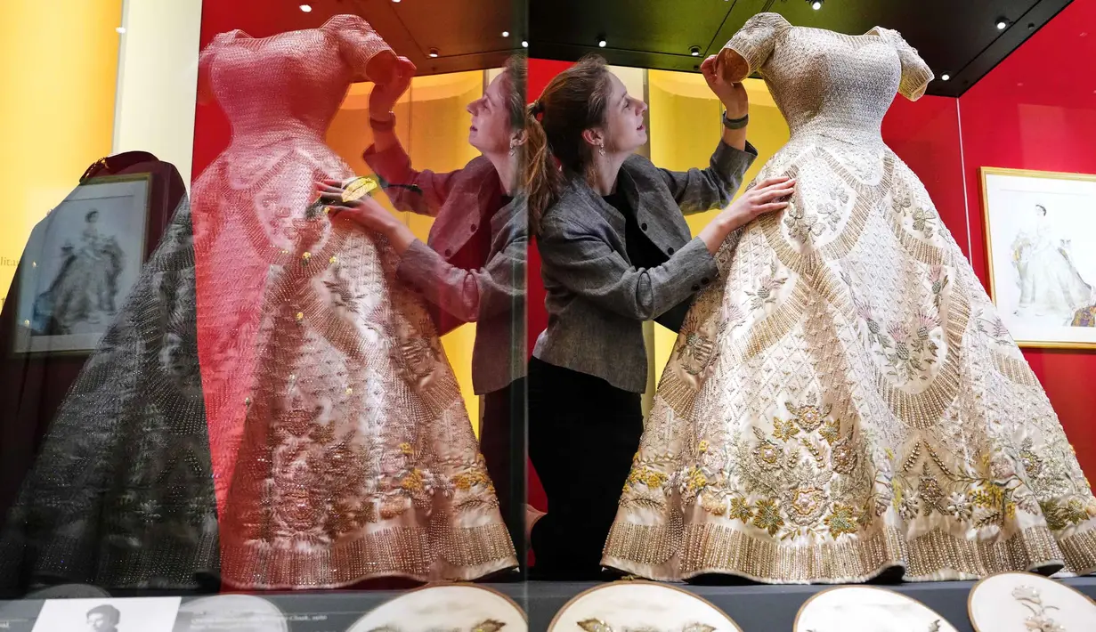 Cecilia Oliver, Konservator Tekstil di Royal Collection Trust, menyesuaikan gaun penobatan yang dikenakan oleh Ratu Elizabeth II, yang dipamerkan di pameran 'Queen Elizabeth II: Her Life in Style', di The King's Gallery, Istana Buckingham, London, Inggris, Kamis 9 April 2026. (AP Photo/Kirsty Wigglesworth)