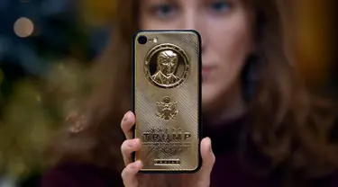 Seorang karyawan dari Caviar Phones memperlihatkan iPhone 7 edisi khusus dengan potret muka Donald Trump di Moskow, Rusia, 14 November 2016. iPhone mewah ini juga ditaburi dengan kristal Svarowsky dan titanium di beberapa sisinya. (Vasily Maximov/AFP)