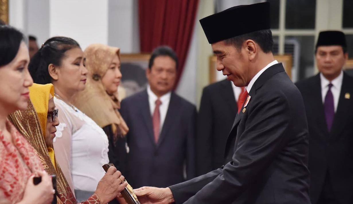 Presiden Joko Widodo (kanan) memberikan gelar Pahlawan Nasional kepada ahli waris di Istana Negara, Jakarta, Jumat (8/11/2019). Jokowi memberikan gelar Pahlawan Nasional kepada enam tokoh yang dianggap berjasa untuk Indonesia. (Foto: Lukas-Biro Pers Sekretariat Presiden)
