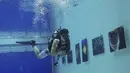 Penyelam melihat pameran foto yang dipamerkan dalam air di Inner Space Club, Beijing, China, Kamis (5/11). 40 karya foto bawah laut dipamerkan untuk memberikan pengalaman menyaksikan pameran foto yang tidak biasa kepada pengunjung (REUTERS/Kim Kyung-Hoon)
