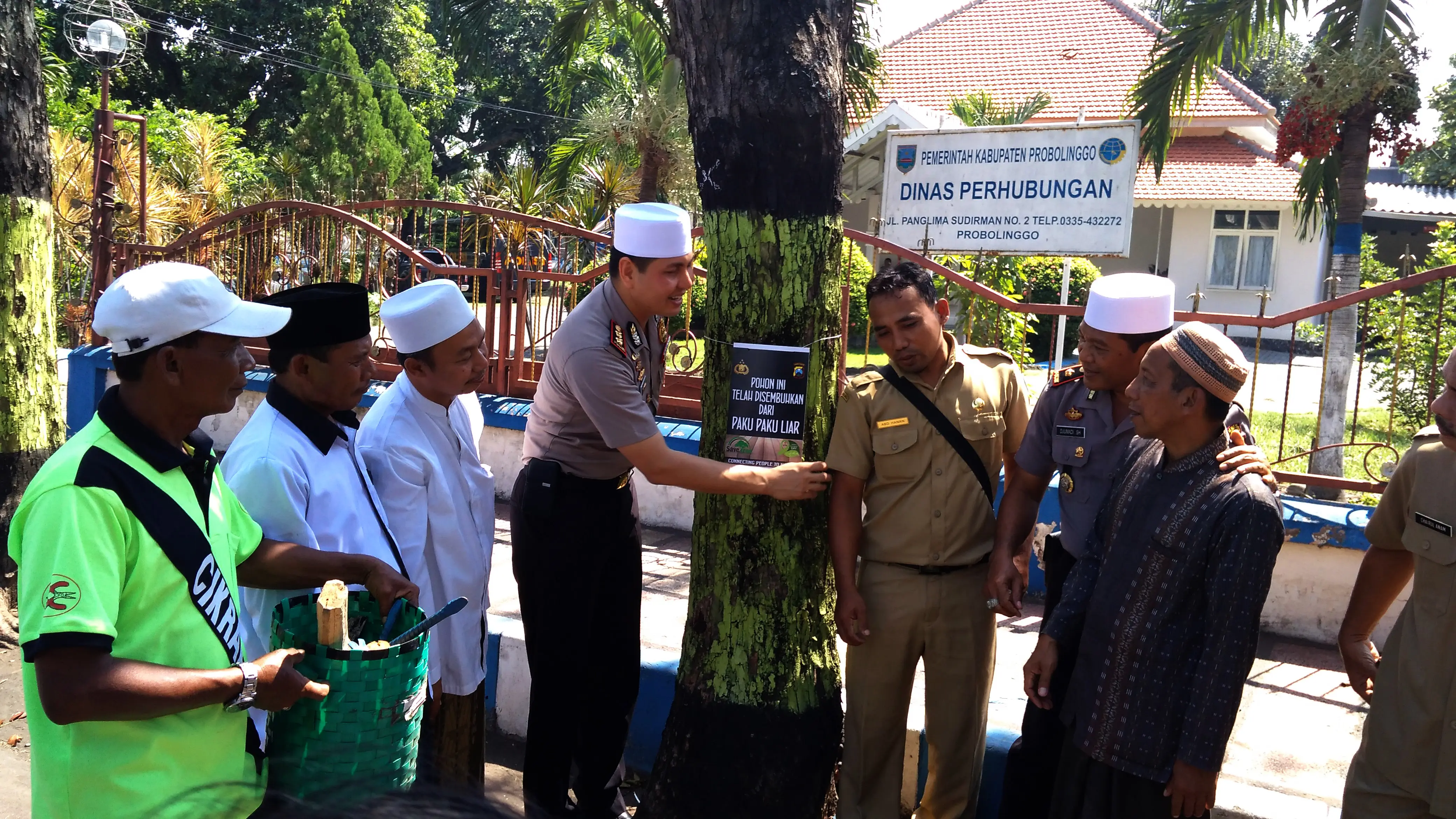 Jajaran Polresta Probolinggo, Jawa Timur dan santri Ponpes An-Nur menggelar aksi cabut paku di pohon-pohon sepanjang jalan protokol. (Liputan6.com/Dian Kurniawan)