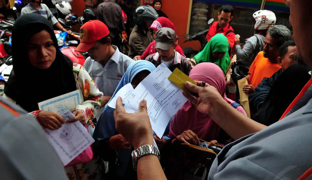 Terlihat beberapa orang antre dengan membawa KTP, surat undangan, dan kartu perlindungan sosial (KPS) milik mereka, Jakarta, Rabu (19/11/2014). (Liputan6.com/Johan Tallo)