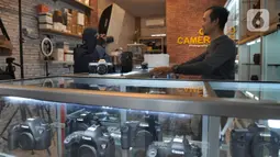 Calon pembeli mencoba kamera bekas  yang dijual belikan di CSZ Camera di kawasan Pondok jagung, Tangerang Selatan, Banten, Senin (20/12/2021). Peningkatan penjualan didorong karena kebutuhan memotret untuk komunitas dan media visual penjualan online. (merdeka.com/Arie Basuki)