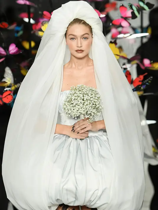Supermodel Gigi Hadid berjalan di runway mengenakan gaun Moschino untuk koleksi SS19 selama gelaran fashion week di Milan, Italia, Kamis (20/9). Untuk riasan wajahnya,  Gigi didandani dengan  pulasan lipstik warna dark plum. (AFP/Marco BERTORELLO)