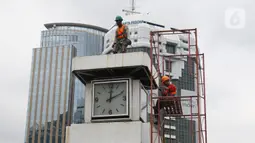 Petugas melakukan perawatan tugu jam yang berada di Merdeka Selatan, Jakarta, Minggu (2/2/2020). Perawatan tersebut dilakukan untuk pengecekan kondisi jam yang nantinya akan dipasangkan panel surya sebagai daya power agar tugu jam dapat berfungsi sebagai petunjuk waktu. (Liputan6.com/Angga Yuniar)