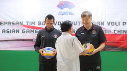 Ketua Umum PBVSI, Imam Sudjarwo (tengah) memberikan bola voli kepada pelatih Timnas Bola Voli Indoor Putra Indonesia, Jeff Jiang Jie (kanan) dan pelatih Timnas Bola Voli Pantai Indonesia, Agus Salim saat pelepasan Timnas Bola Voli Indonesia untuk Asian Games 2022 Hangzhou di Padepokan Voli Jenderal Kunarto, Sentul, Bogor, Kamis (14/09/2023). (Bola.com/Bagaskara Lazuardi)