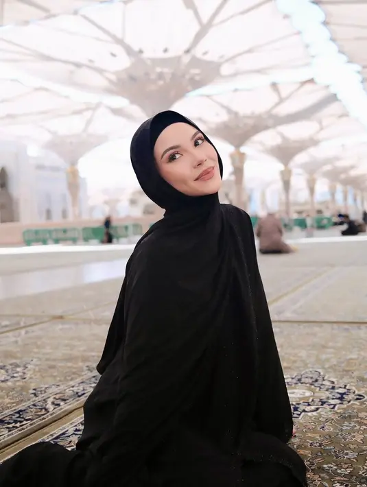 Selama umrah, gaya hijab Alyssa Daguise menjadi sorotan karena sederhana namun tetap elegan. Di Masjid Nabawi, ia terlihat mengenakan abaya hitam dengan hijab serasi, lengkap dengan kacamata hitam yang membuat tampilannya terlihat modern. Ekspresi khusyuk dan ketenangan yang terpancar dari dirinya mencerminkan kedamaian spiritual yang ia rasakan. (Liputan6.com/IG/@alyssadaguise)