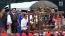 Presiden Joko Widodo mencoba alat penenun kain di Festival Sarung Indonesia 2019, Plaza Tenggara Kompleks GBK, Jakarta, Minggu (3/3). Festival ini untuk menghidupkan kesadaran generasi muda akan kekayaan budaya Indonesia. (Liputan6.com/Helmi Fithriansyah)